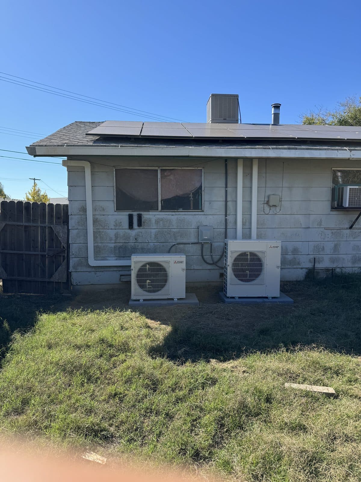 Multiple mini-split outdoor units installed on home exterior wall